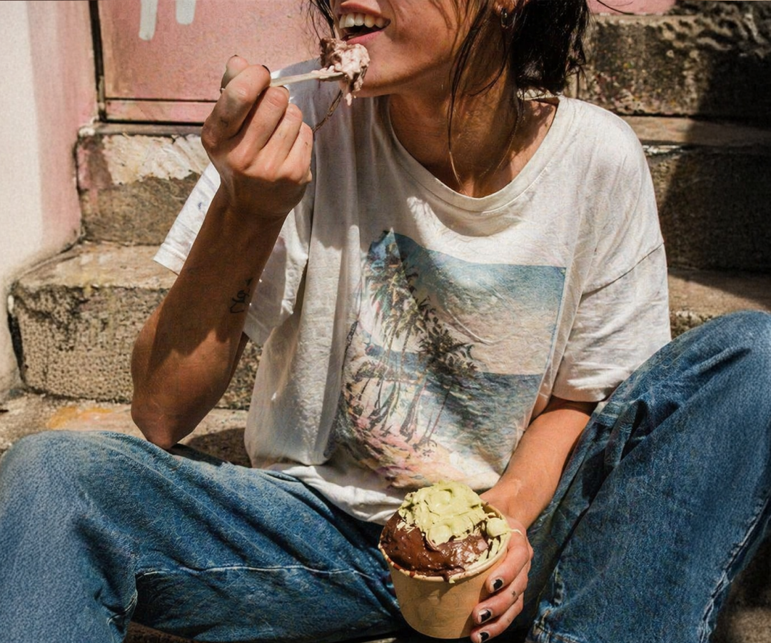 Daire customer eating two-flavor gelato outdoors — sunny ice cream moment